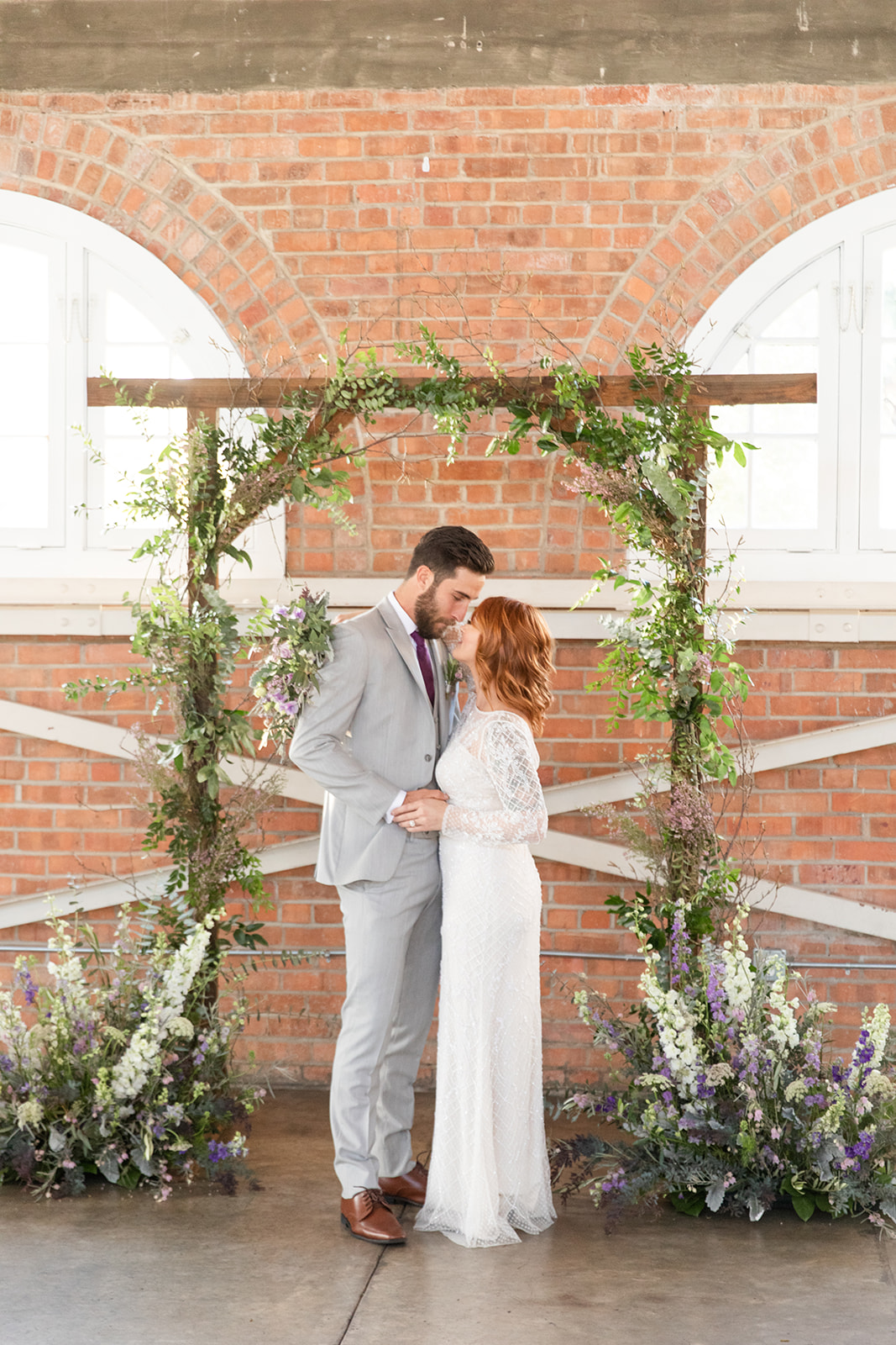 wedding arch, flowers, first kiss
