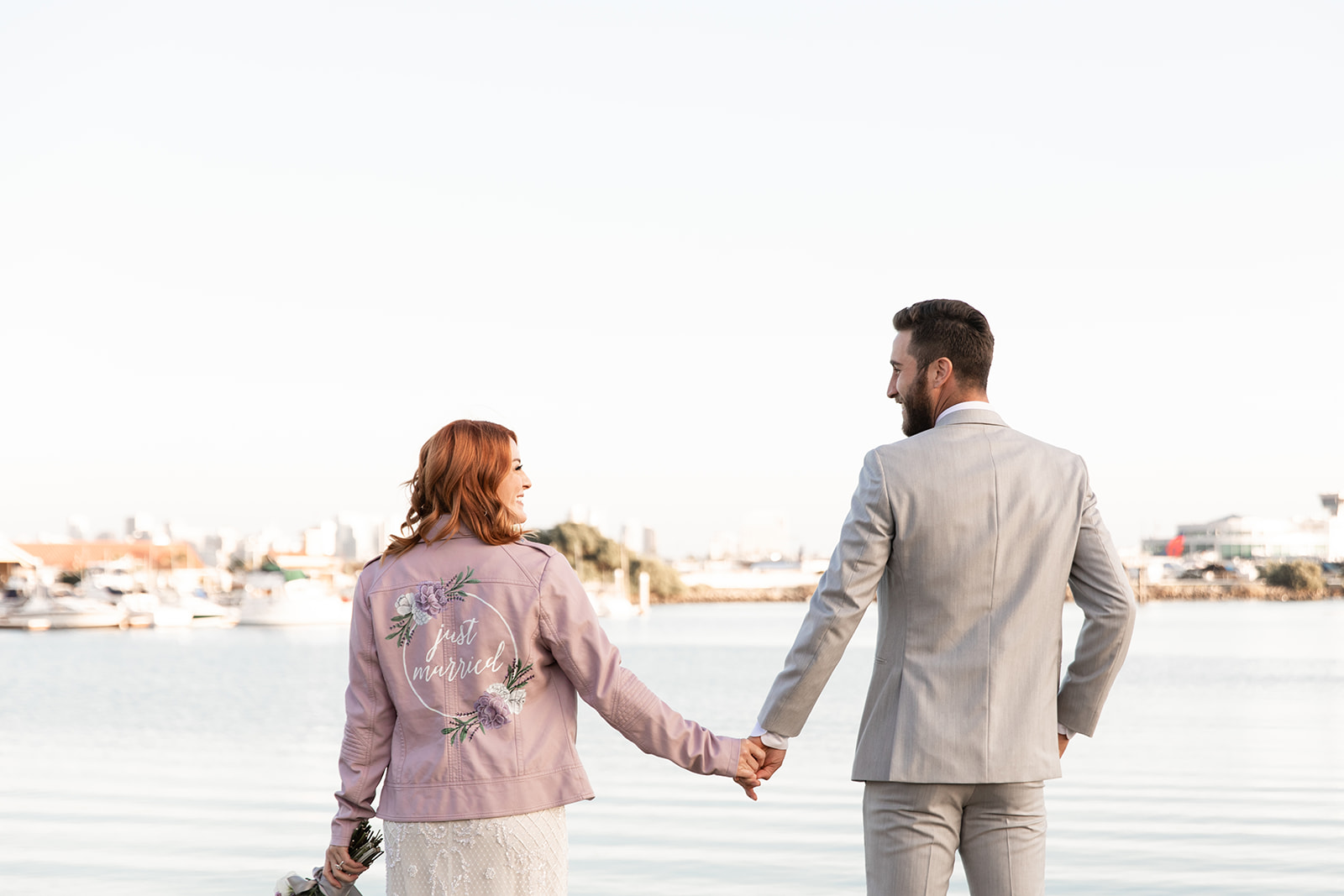 bride and groom, purple leather jacket, holding hands